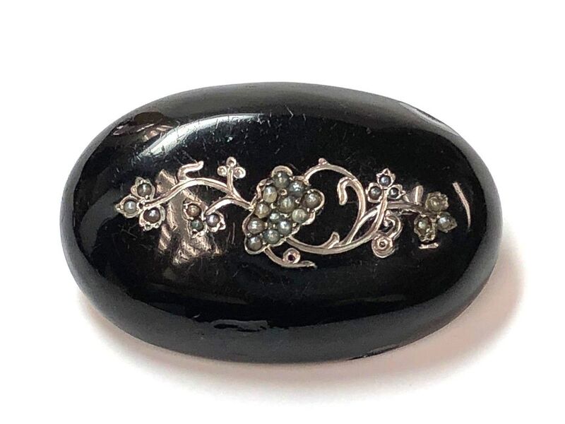A Victorian Era antique sterling silver mourning brooch with black enamel and seed pearls