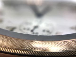 Abrasions along the faceted edge of this glass pocket watch crystal.