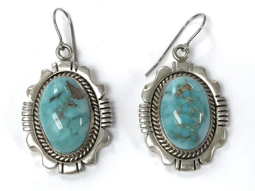 The turquoise in these vintage Navajo earrings has beautiful matrix visible, recessed slightly beneath the polished surface.