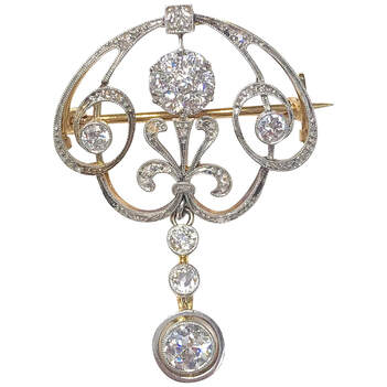 Approximately 1.50 carats of old cut diamonds are set in this Edwardian Era platinum-topped 18K yellow gold pendant brooch.