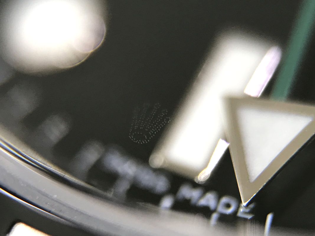 Authentic Rolex Crown etched into the underside of the crystal, at six o'clock.
