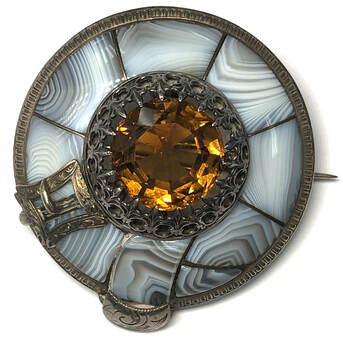 Mid Victorian Era antique blue lace agate brooch featuring a natural citrine set in an ornate fleur-de-lis 18-prong basket, completely hand chased
