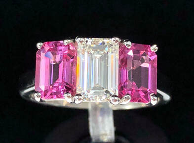 Platinum 3-stone ring with a GIA 1.05 ct G VS1 emerald cut diamond center and 2 GIA no heat vivid pink sapphire emerald cut side stones