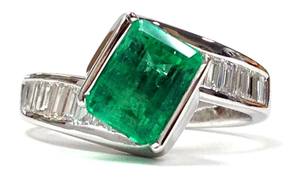 Diagonally set emerald cut emerald & channel set baguette diamond ring in white gold