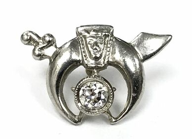 An old transitional cut diamond is set in a platinum millegrain setting in this vintage Masonic Shriner lapel pin