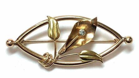 Handmade Art Nouveau Era antique floral brooch featuring a blue zircon set in rose gold, with green gold leaves.