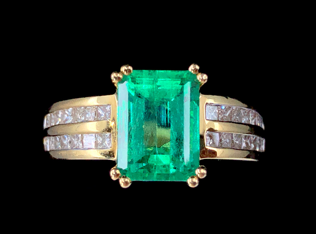 A beautiful 2.73 ct. Natural Colombian Emerald centers this 18K gold and diamond ring.