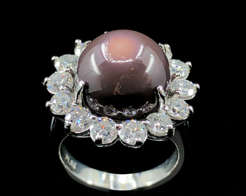 A large quahog pearl and diamond ring in platinum