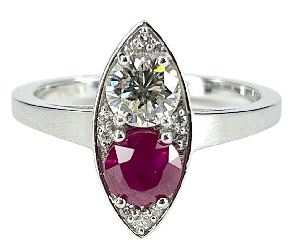 A platinum toi et moi ring featuring a 0.49 ct. diamond and a 0.75 ct. natural ruby