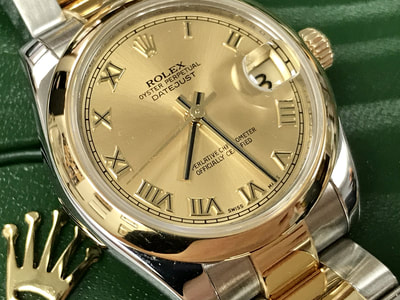 Rolex Datejust 31, 2-tone with a polished domed bezel, steel & gold Oyster bracelet, and a champagne Roman dial.